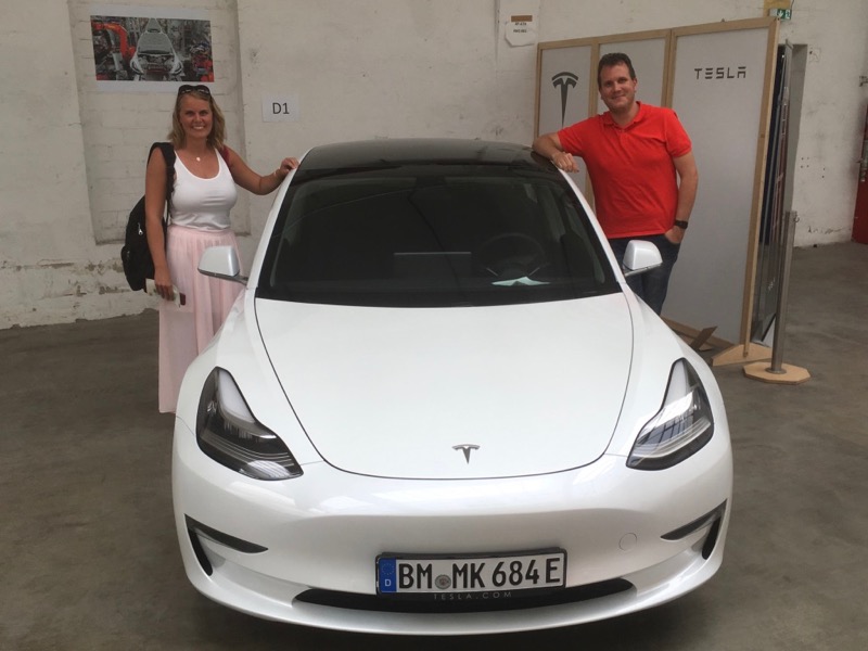 Die neuen Besitzer des Tesla Model 3 bei der Abholung in Neuss