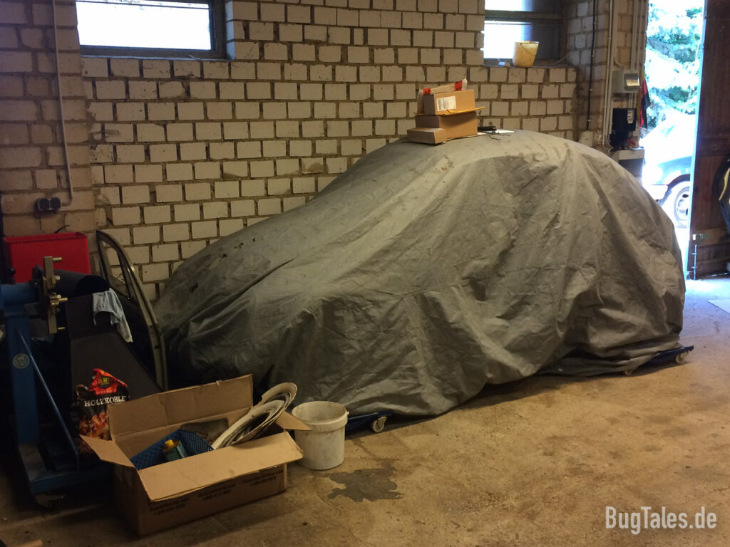 Abgedeckter Volkswagen Käfer in einer Werkstatt