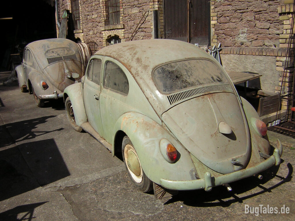 Zwei Volkswagen Käfer vor einer Scheune