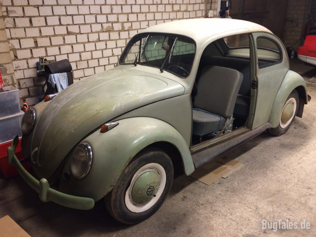 Volkswagen Käfer in einer Werkstatt mit demontierter Fahrertüre.